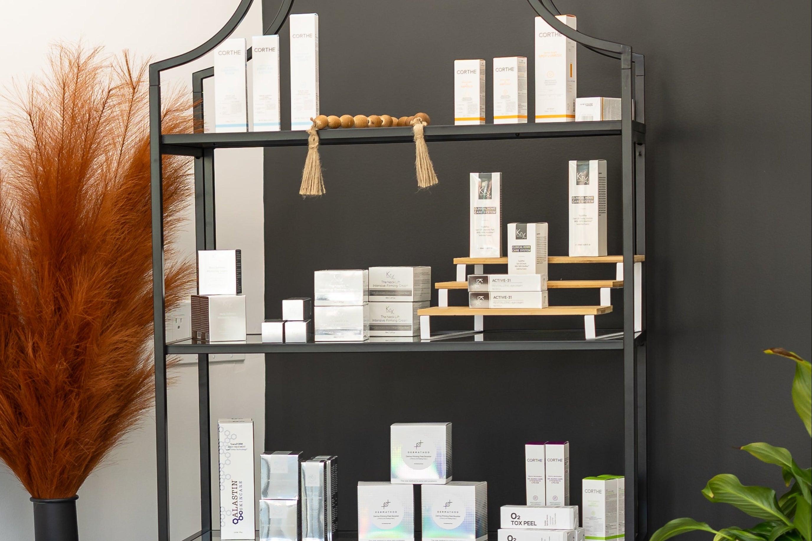 Modern interior design with an orange decoration, black shelving unit with skincare products, and decorative plants.